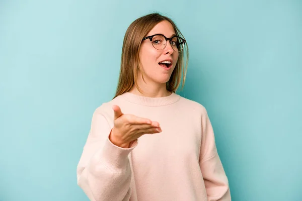 Young Caucasian Woman Isolated Blue Background Stretching Hand Camera Greeting — Stock Photo, Image