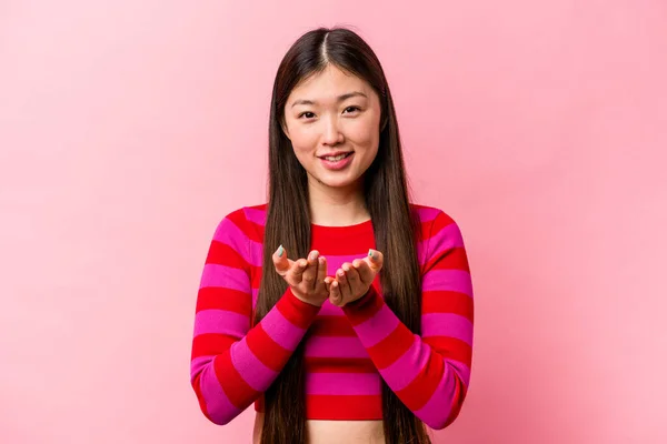 年轻的中国女人 背景是粉色的 手里拿着一些有手掌的东西 主动提出要拍照 — 图库照片