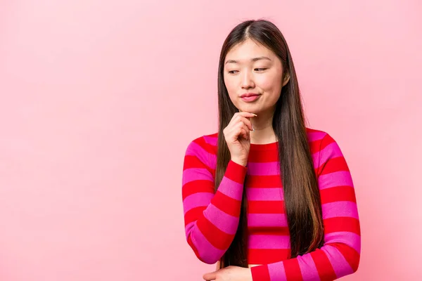 Νεαρή Κινέζα Γυναίκα Απομονωμένη Ροζ Φόντο Κοιτάζοντας Πλάγια Αμφίβολη Και — Φωτογραφία Αρχείου
