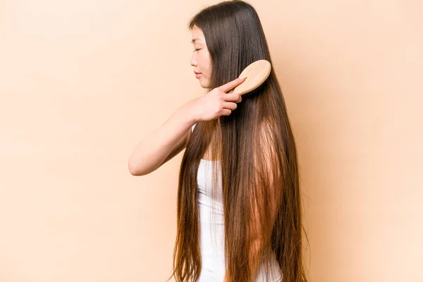 Junge Asiatische Frau Kämmt Ihr Haar Isoliert Auf Beigem Hintergrund — Stockfoto