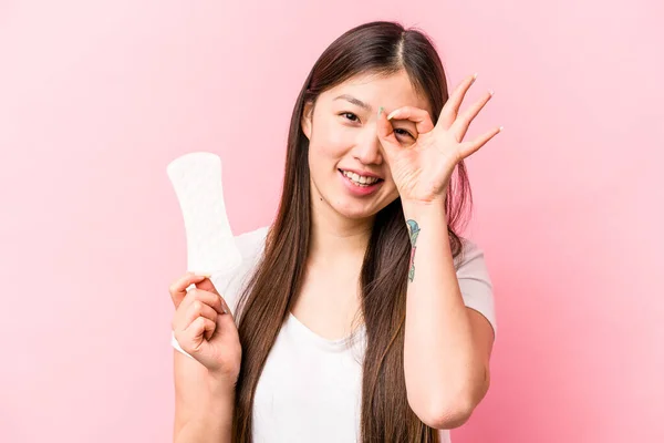 年轻的亚洲女人拿着卫生巾 带着粉红的背景 兴奋地保持着健康的眼神 — 图库照片