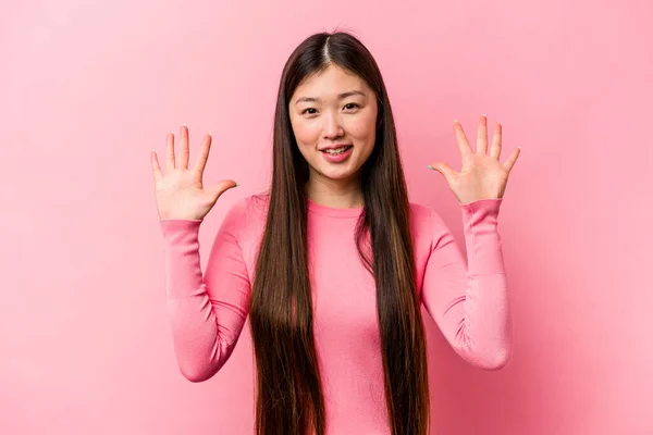 在粉色背景上被隔离的年轻中国女人 手举着十号 — 图库照片
