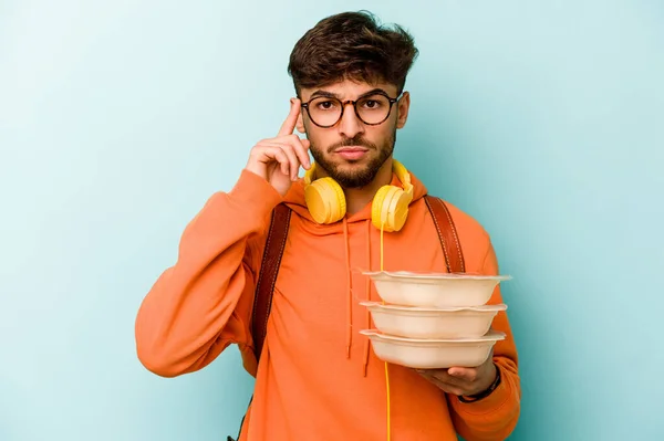 Joven Estudiante Hispano Sosteniendo Tupperware Aislado Sobre Fondo Azul Apuntando — Foto de Stock