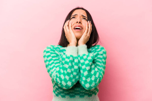 Young hispanic woman isolated on pink background whining and crying disconsolately.