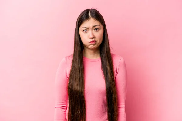 年轻的中国女人在粉红的背景上孤立无援 面容憔悴 面部表达概念 — 图库照片