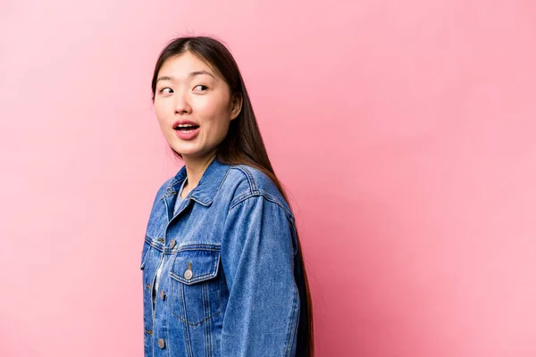 Joven Mujer China Aislada Sobre Fondo Rosa Mira Lado Sonriente —  Fotos de Stock