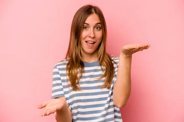 Young Caucasian Woman Isolated Pink Background Makes Scale Arms Feels — Stock Photo, Image