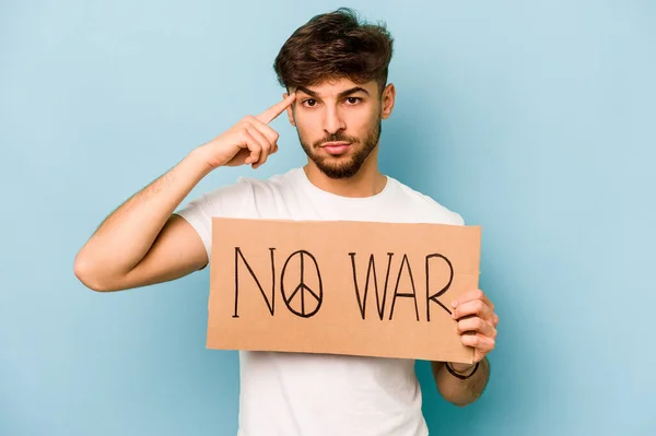 Young hispanic man holding no war placard isolated on white background