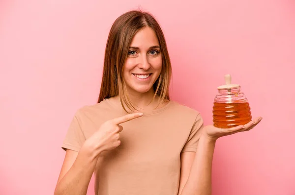 Young Caucasian Woman Holding Honey Isolated Pink Background Smiling Pointing — Stock Photo, Image