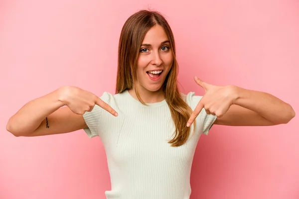 Junge Kaukasische Frau Isoliert Auf Rosa Hintergrund Überrascht Zeigt Mit — Stockfoto