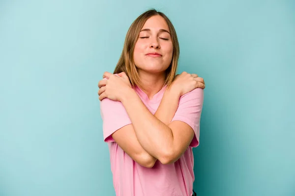 Mujer Caucásica Joven Aislada Los Abrazos Fondo Azul Sonriente Despreocupada — Foto de Stock