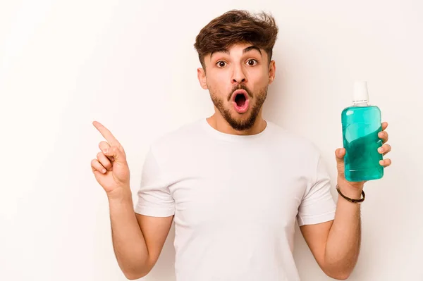 Young Hispanic Man Holding Mouthwash Isolated White Background Pointing Side — Stok Foto