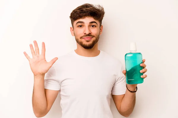 Young Hispanic Man Holding Mouthwash Isolated White Background Smiling Cheerful — Stok fotoğraf