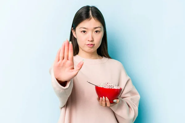 Jonge Aziatische Vrouw Met Een Kom Granen Geïsoleerd Blauwe Achtergrond — Stockfoto