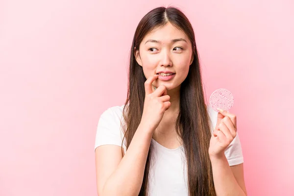 Joven Mujer Asiática Sosteniendo Esponja Facial Aislada Sobre Fondo Rosa — Foto de Stock