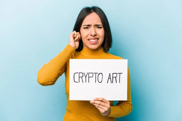 Mladá Hispánka Drží Kryptografický Plakát Izolované Modrém Pozadí Zakrývající Uši — Stock fotografie