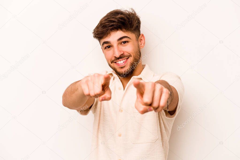 Young hispanic man isolated on white background pointing to front with fingers.
