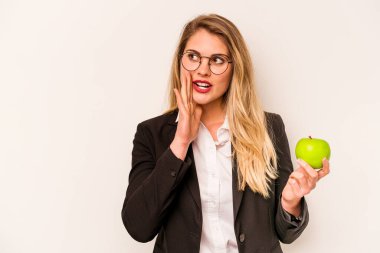 Beyaz arka planda izole edilmiş bir elma tutan beyaz iş kadını gizli sıcak fren haberini veriyor ve yana bakıyor.