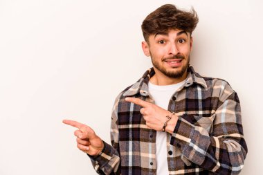 Beyaz arka planda izole edilmiş genç İspanyol adam işaret parmağıyla fotokopi alanını işaret ederek şok oldu..