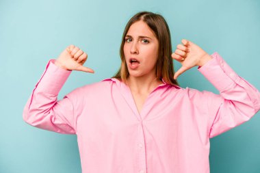 Mavi arka planda izole genç beyaz kadın gururlu ve kendinden emin hissediyor, örnek olarak..