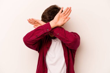 Beyaz arka planda izole edilmiş genç İspanyol adam iki kolu çapraz tutuyor, inkar kavramı.