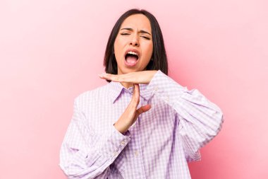 Pembe arka planda izole edilmiş genç İspanyol kadın bir mola hareketi gösteriyor..