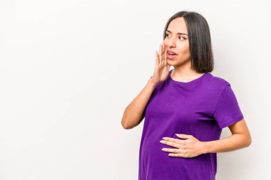 Beyaz arka planda izole edilmiş genç Latin kökenli hamile kadın gizli bir fren haberi veriyor ve bir kenara bakıyor.