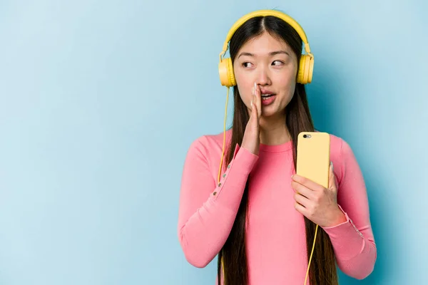 Jovem Mulher Asiática Ouvindo Música Isolada Fundo Azul Está Dizendo — Fotografia de Stock
