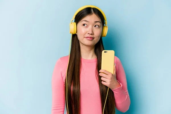 Jonge Aziatische Vrouw Luisteren Naar Muziek Geïsoleerd Blauwe Achtergrond Dromen — Stockfoto