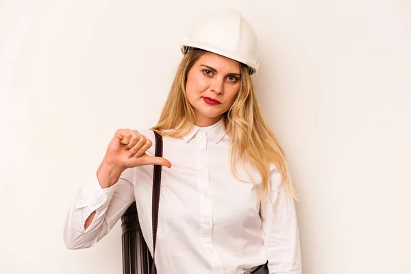 Young architect woman with helmet and holding blueprints isolated on white background showing a dislike gesture, thumbs down. Disagreement concept.