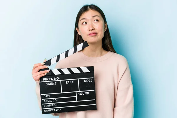 Young Asian Woman Holding Clapperboard Isolated Blue Background Dreaming Achieving — Stock Photo, Image