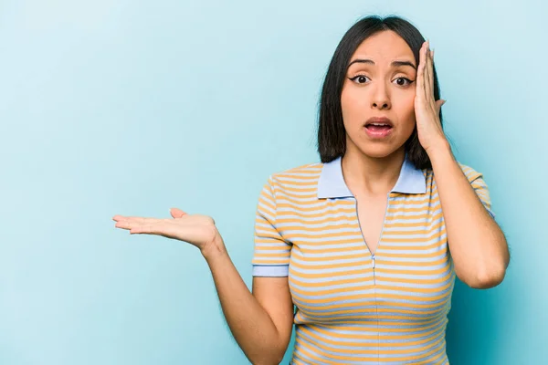 Junge Hispanische Frau Isoliert Auf Blauem Hintergrund Beeindruckt Hält Kopierraum — Stockfoto