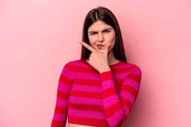 Pembe arka planda izole edilmiş genç beyaz kadın bir strateji planlıyor, bir iş kurmanın yollarını düşünüyor..