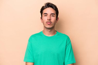 Beyazlı genç bir adam bej arka planda izole edilmiş üzgün, ciddi yüzlü, mutsuz ve hoşnutsuz..