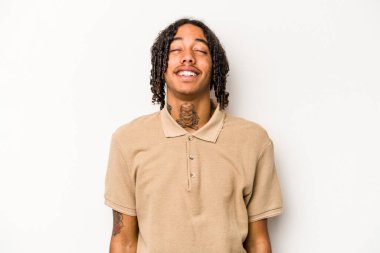 Beyaz arka planda izole edilmiş genç bir Afrikalı Amerikalı. Rahatlamış ve mutlu bir şekilde gülüyor. Dişlerini göstererek boynunu geriyor..
