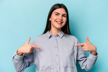 Mavi arka planda izole edilmiş genç beyaz kadın parmakları aşağıda, olumlu bir his var..