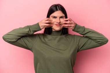 Pembe arka planda izole edilmiş beyaz bir kadın iki seçenek arasında şüphe duyuyor..