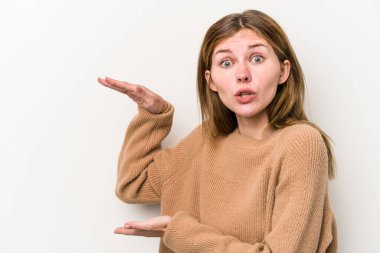 Beyaz arka planda izole edilmiş genç bir Rus kadın elleri arasında bir kopya alanı tutarken şok ve hayrete düştü..