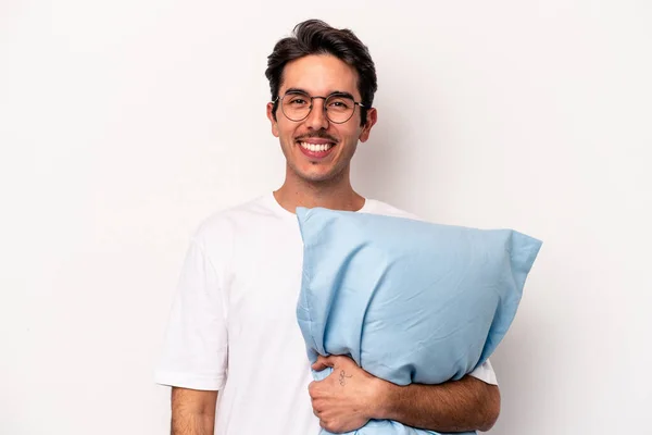 白い背景に孤立した枕を持ってパジャマを身に着けている若い白人男性幸せ 笑顔と陽気 — ストック写真