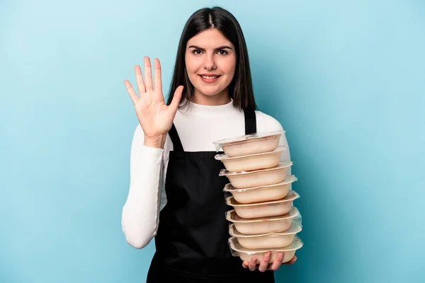 Ung Kaukasiska Kvinna Håller Tupperware Isolerad Blå Bakgrund Ler Glad — Stockfoto