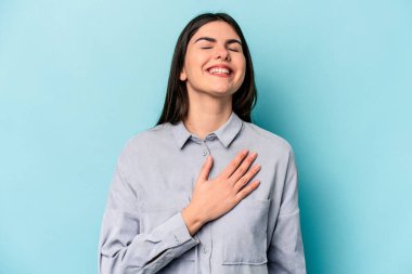 Mavi arka planda yalnız yaşayan beyaz bir kadın elini göğsüne koyduğunda kahkahalar atıyor..