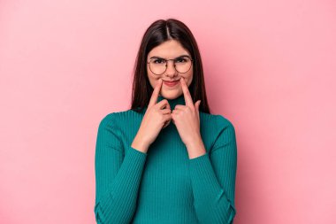 Pembe arka planda izole edilmiş beyaz bir kadın iki seçenek arasında şüphe duyuyor..