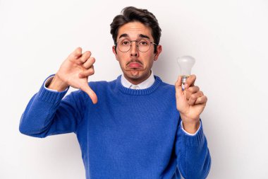 Beyaz arka planda izole edilmiş bir ampul tutan beyaz tenli genç adam, hoş olmayan bir jest gösteriyor, kabul etmiyor. Anlaşmazlık konsepti.