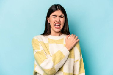 Mavi arka planda izole edilmiş, omuz ağrısı olan beyaz bir kadın..