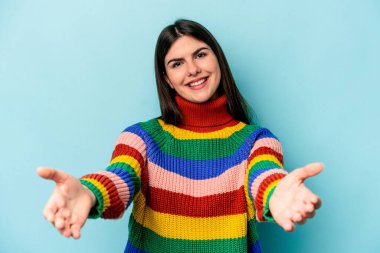 Mavi arka planda izole edilmiş beyaz bir kadın hoş bir ifade sergiliyor..