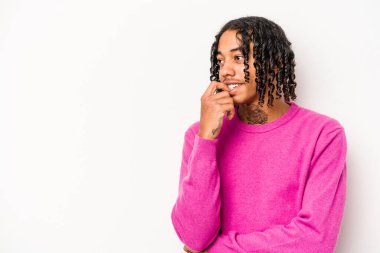 Beyaz arka planda izole edilmiş genç Afrikalı Amerikalı bir şey hakkında rahatça düşünüyor ve bir fotokopi odasına bakıyor..