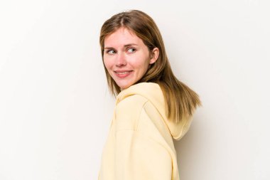 Beyaz arka planda izole edilmiş genç Rus kadın gülümseyen, neşeli ve keyifli bir kenara bakıyor..