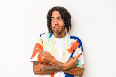 Beyaz arka plan noktalarında izole edilmiş genç Afrikalı Amerikalı iki seçenek arasında seçim yapmaya çalışıyor..