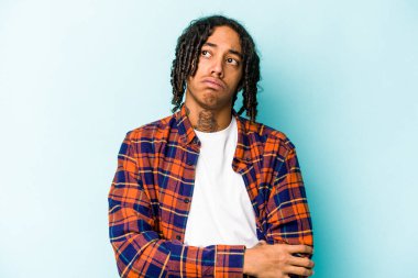 Genç Afrikalı Amerikalı adam mavi arka planda izole edilmiş. Tekrarlanan bir görevden yorulmuş..