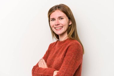 Beyaz arka planda izole edilmiş genç bir Rus kadın, kendinden emin, kararlılıkla kollarını kavuşturuyor..